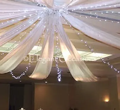 Ceiling draping with soft fabric and fairy lights for event styling